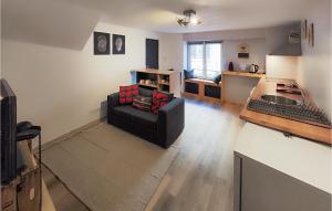 ein Wohnzimmer mit einem schwarzen Sofa und einer Küche in der Unterkunft Beautiful Apartment In Bessan With Wifi in Bessan
