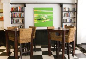 two tables and chairs in a library with bookshelves at Hostal Tierramar in El Arenal