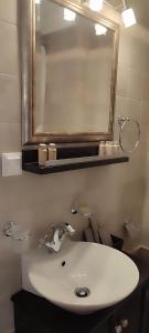 a bathroom with a white sink and a mirror at Αρχοντικό Ταξίμι (Μουντζουρίδη) in Argalasti