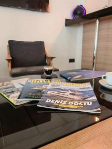 uma mesa de vidro com revistas e jornais em Alesta Seaside Residence em Fethiye