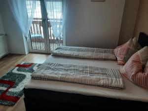 three beds in a room with a balcony at Apartment - Ferienwohnung 2 Treffen am Ossiachersee in Treffen