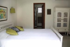 a white bed with two pillows in a bedroom at Modern Villa with service. Exceptional beach, private swimming pool in Roches Noires