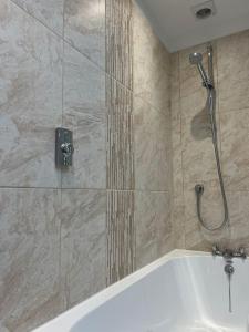 un baño con ducha y bañera en The Hideaway Southport, en Southport