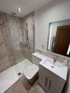 a bathroom with a shower and a toilet and a sink at The Hideaway Southport in Southport