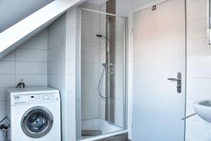 a bathroom with a shower and a washing machine at Nordsee Anker Unsere moderne 87 qm Ferienwohnung mit zwei Schlafzimmer in Norden Ortsteil Ostermarsch in Norden