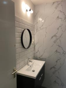 a bathroom with a sink and a marble wall at Blom aan de Gracht in Dordrecht