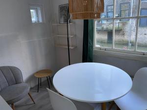 una mesa y sillas blancas en una habitación con ventana en Blom aan de Gracht en Dordrecht