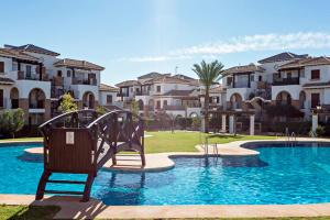 a playground in front of a swimming pool with houses at Casa Manuela in Vera