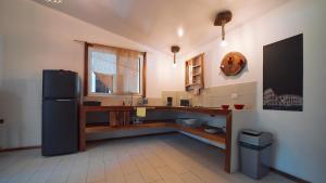 a kitchen with a black refrigerator and a table at Olivia del caribe suite in Puerto Viejo