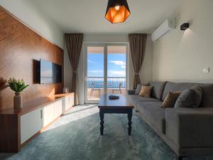 a living room with a couch and a view of the ocean at Garden Recovery in Sveti Stefan