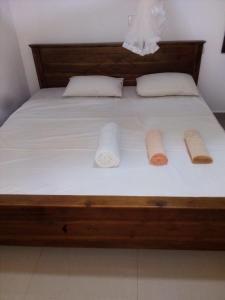 a bed with two pillows and two towels on it at Rithu Homestay in Sigiriya