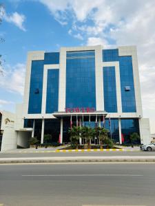 a large building with a sign on the front of it at Towers Hotel alqassim in Buraydah