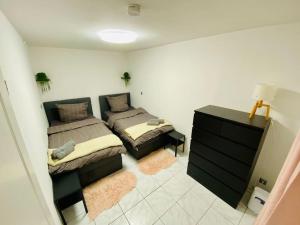 a bedroom with two beds and a dresser in it at Ferienwohnung mit Talblick für Monteure in Kirschhausen