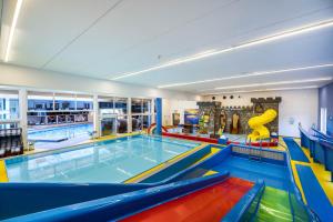 a large indoor swimming pool with a slide in it at Schlosshotel Lacknerhof in Flachau +117 photos