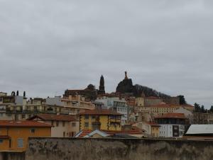 a view of a city with buildings and a hill at Appartement moderne in Le Puy-en-Velay
