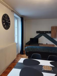 een kamer met een grote klok aan de muur bij Appartement moderne in Le Puy en Velay