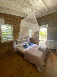 une chambre avec un lit avec moustiquaire dans l'établissement Villa Titi, à Saint-François