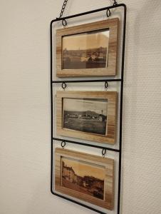 twee ingelijste foto's van treinen hangen aan een muur bij Appartement moderne in Le Puy en Velay