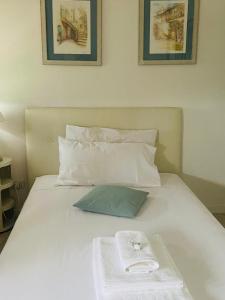 a white bed with a towel on top of it at La terrazza di Nerone in Anzio