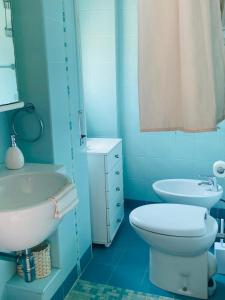 a blue bathroom with a toilet and a sink at La terrazza di Nerone in Anzio