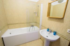 a bathroom with a white tub and a sink and a bath tub at Hotel Apart Tel Aviv in Sebeş +16 photos