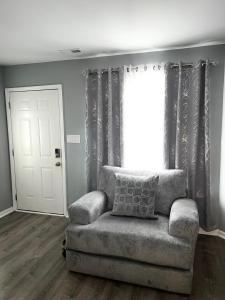 a living room with a chair and a window at Luxury Townhome Jacksonville, NC in Jacksonville