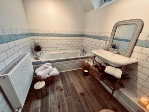 W łazience znajduje się umywalka, wanna i lustro. w obiekcie 6 - Central Location - Roll Top Bath - Free Parking w mieście Merthyr Tydfil