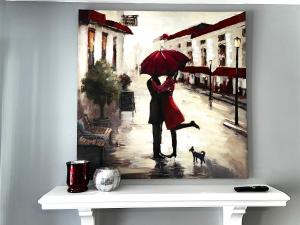 una pintura de una pareja con un perro bajo la lluvia en Luxury Townhome Jacksonville, NC en Jacksonville