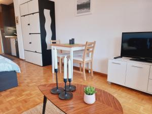 een woonkamer met een tafel en een televisie bij Le Cleuson - centré avec vue in Nendaz