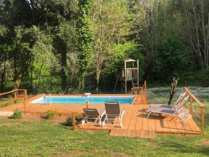 une terrasse avec deux chaises et une piscine dans l'établissement Glamping Pian delle Ginestre, à Sassetta