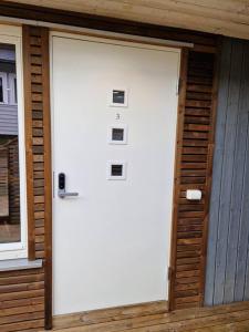 une porte de garage blanche sur le côté de la maison dans l'établissement Stilren suite med egen inngang og kokemuligheter., à Tromsø