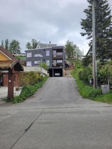 une rue vide avec un bâtiment en arrière-plan dans l'établissement Stilren suite med egen inngang og kokemuligheter., à Tromsø