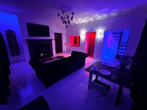 a living room with a couch and a fireplace with red and blue lights at Lower Winsford Apartments & Rooms in Bideford