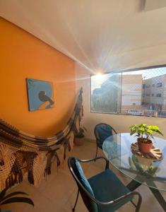 a dining room with a glass table and chairs at Casa 90m, dois quartos, próxima às praias in Maceió