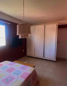 a bedroom with a bed and a cabinet at Casa 90m, dois quartos, próxima às praias in Maceió