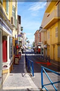 une rue de la ville avec des bâtiments et une clôture bleue dans l'établissement Au coeur de Bandol, à Bandol