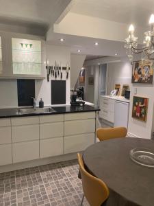 a kitchen with white cabinets and a table with chairs at Skovbakkegaardens Bed & Bath - Værelser med eget bad in Aalborg