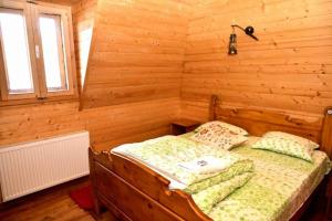 a bedroom with a bed in a wooden room at PENSIUNEA VESELIA in Botiza
