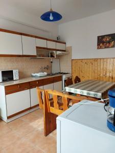 a kitchen with white cabinets and a table and a tableablish at Sövényes Szálláshely in Barcs