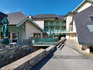 un edificio con una pasarela delante de él en Studio les Pieds dans L'eau au bord du lac d'Annecy, en Duingt