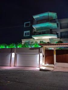 uma casa com portas brancas de garagem à noite em Chalkida Hilltop Apartments em Chalkida