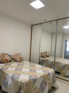 1 dormitorio con 2 camas y un espejo grande en Apart Barra da Tijuca, en Río de Janeiro