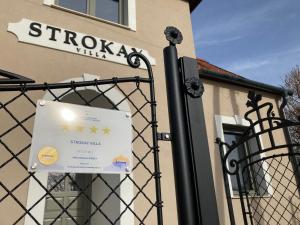 een bord op een poort voor een gebouw bij Villa Strokay - Few minutes walk from Lake Balaton in Keszthely