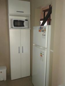 a kitchen with a microwave on top of a refrigerator at Arenas 497 in Pinamar