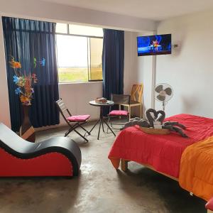 Lima Airport Hostel with FREE AIRPORT PICK UP في ليما: غرفة نوم بسرير وتلفزيون وطاولة