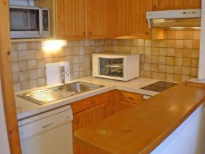 eine Küche mit einer Spüle und einer Mikrowelle in der Unterkunft Appartement Samoëns, 2 pièces, 4 personnes - FR-1-629-72 in Samoëns