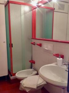 a bathroom with a sink and a toilet and a mirror at La Finestra sul Cervino in Breuil-Cervinia