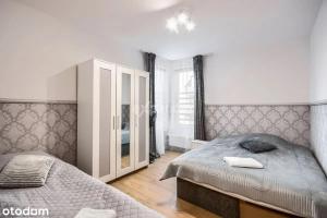 sypialnia z 2 łóżkami i lustrem w obiekcie LUKSUSOWY Gaj Apartament we Wrocławiu
