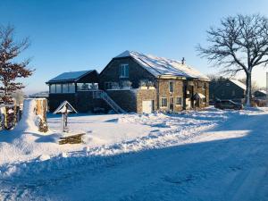 een huis in de sneeuw met een bord in de straat bij PEGASUS I - 2 chambres de luxe, cuisine, salon, 2 terrasses et sauna in Vielsalm