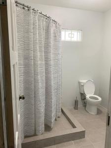 a bathroom with a toilet and a shower curtain at The Blue Moroccan Door - A modern 3 bedroom,2 bathroom home 